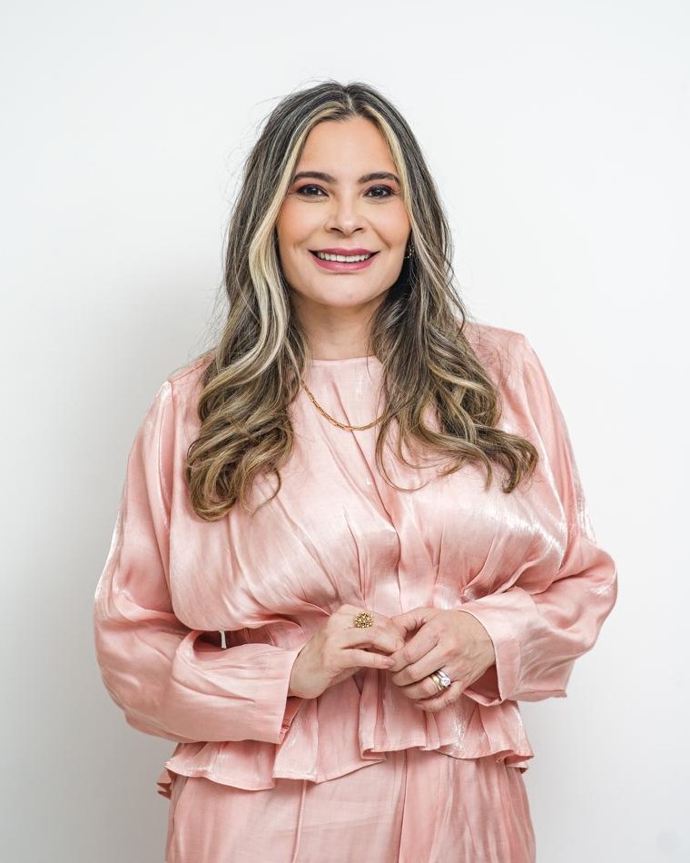 Dra. Silvia Helena Rodrigues, sorrindo, com blusa de cetim rosé